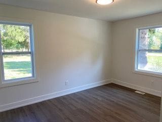 unfurnished room with dark hardwood / wood-style flooring