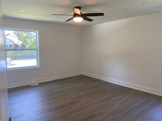 empty room with ceiling fan and dark wood-type flooring