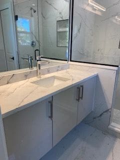 bathroom featuring vanity and an enclosed shower