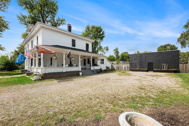 back of property featuring covered porch