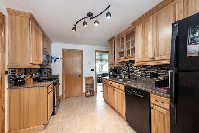 kitchen featuring sink, backsplash, black appliances, and dark stone countertops