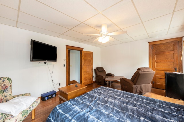 bedroom featuring ceiling fan, a paneled ceiling, and hardwood / wood-style flooring