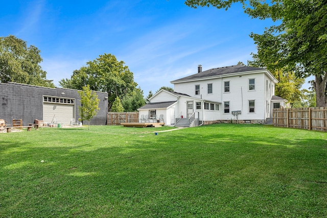 rear view of property with a lawn and a deck