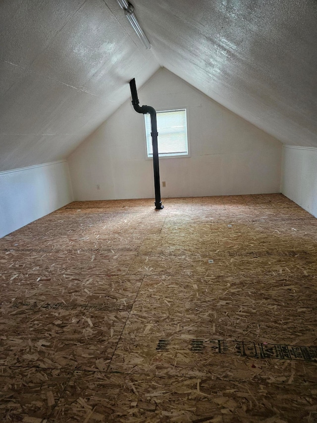 bonus room with a textured ceiling and vaulted ceiling