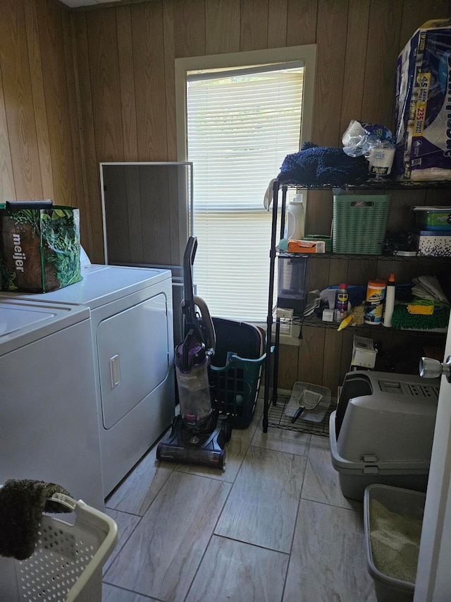 washroom with wooden walls and washing machine and clothes dryer