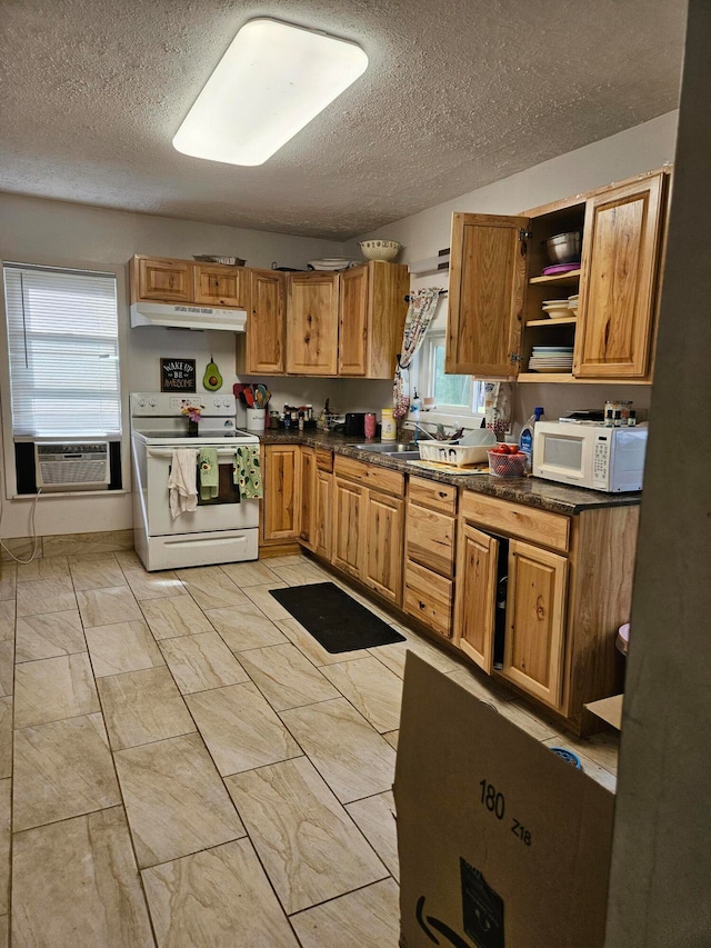 kitchen featuring a textured ceiling, white appliances, an AC wall unit, and sink