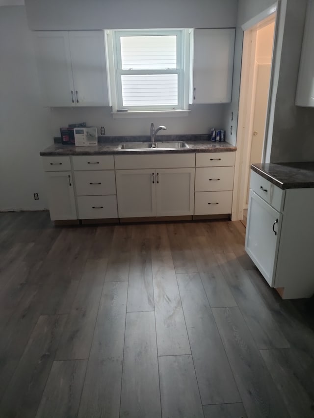 kitchen featuring dark hardwood / wood-style flooring, white cabinetry, and sink