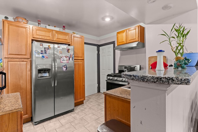 kitchen with kitchen peninsula, light stone counters, and stainless steel appliances