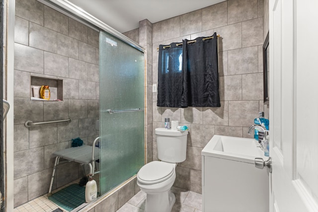 bathroom featuring walk in shower, tile patterned floors, toilet, vanity, and tile walls