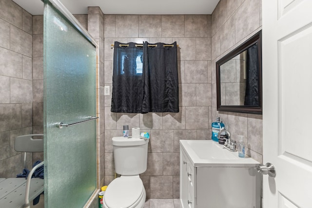 bathroom featuring tile patterned flooring, vanity, toilet, and tile walls