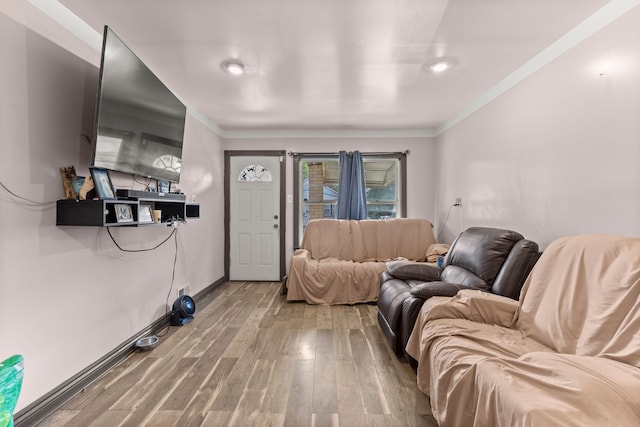 living room featuring hardwood / wood-style floors and crown molding