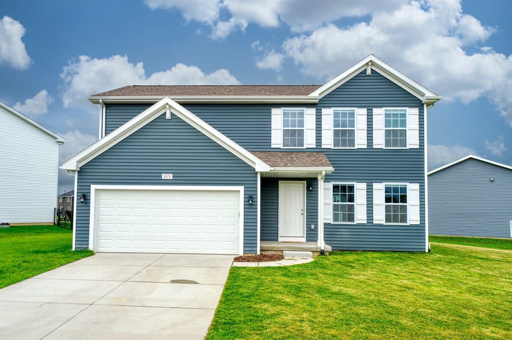 view of front of house featuring a front lawn and a garage