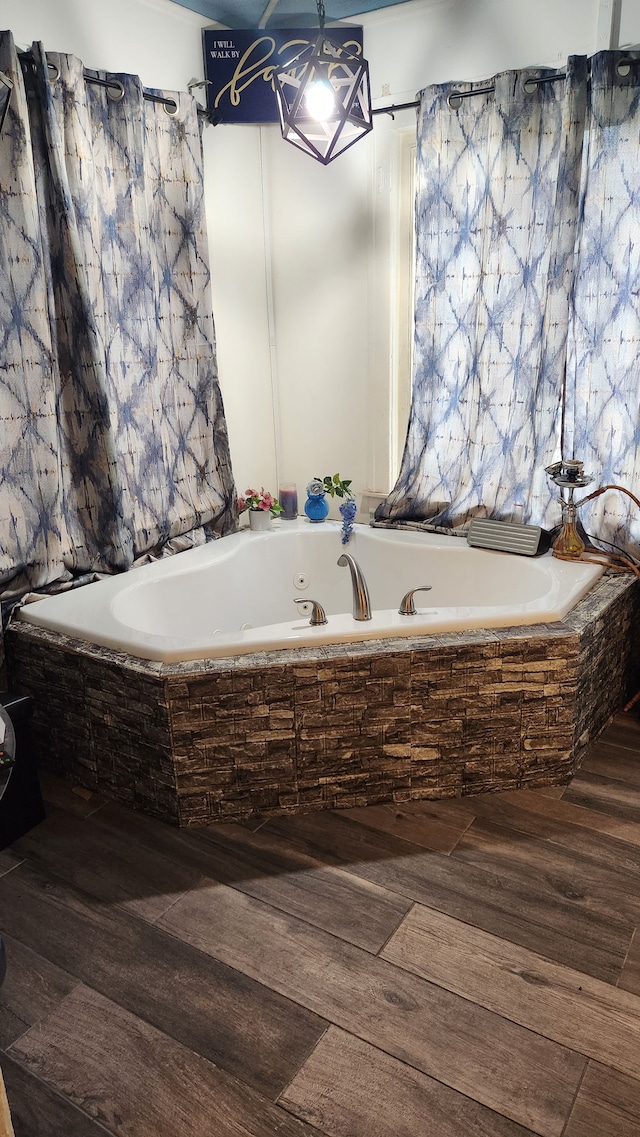 bathroom featuring hardwood / wood-style flooring and tiled bath