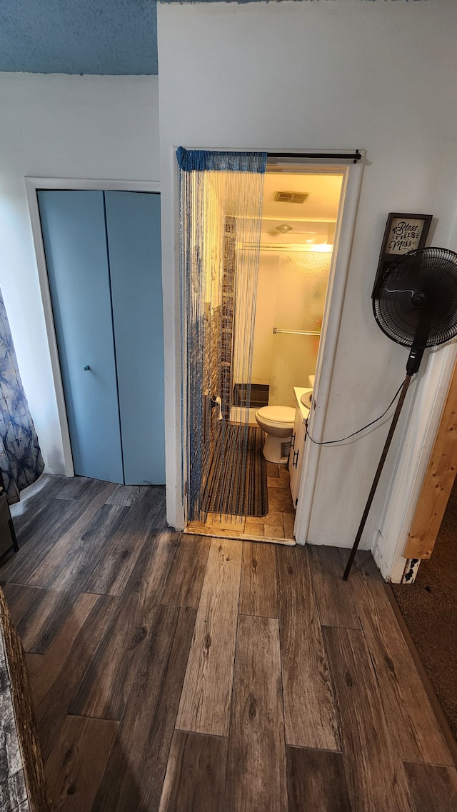 bathroom featuring toilet and wood-type flooring