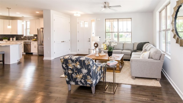 living room with ceiling fan, a healthy amount of sunlight, dark hardwood / wood-style flooring, and sink