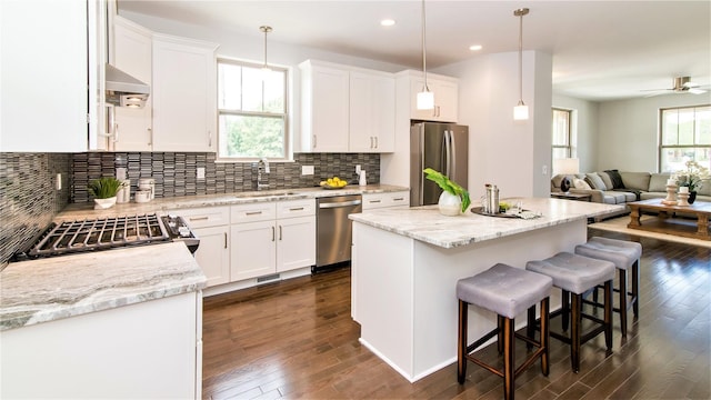 kitchen with white cabinetry, pendant lighting, a kitchen island, and stainless steel appliances