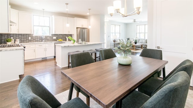 dining area with ceiling fan, light hardwood / wood-style floors, sink, and a wealth of natural light