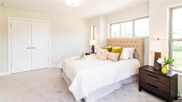 bedroom with light carpet and a closet