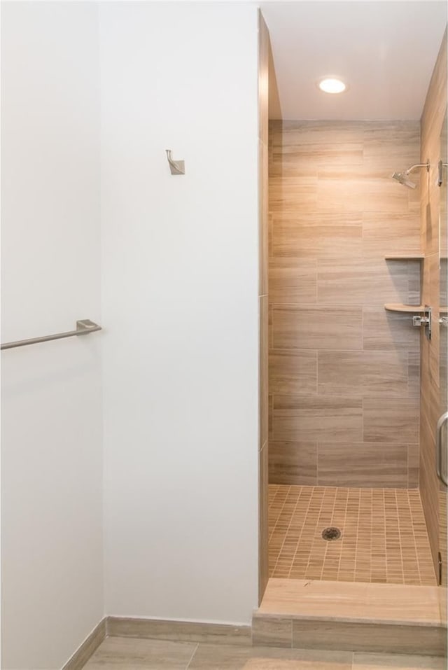 bathroom featuring a shower with shower door and hardwood / wood-style flooring