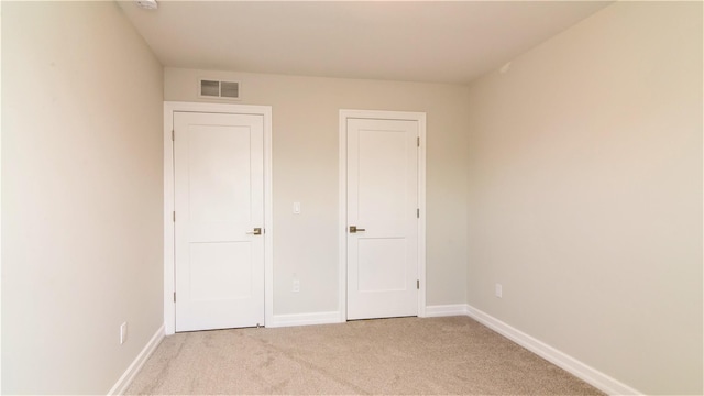 unfurnished bedroom featuring light carpet