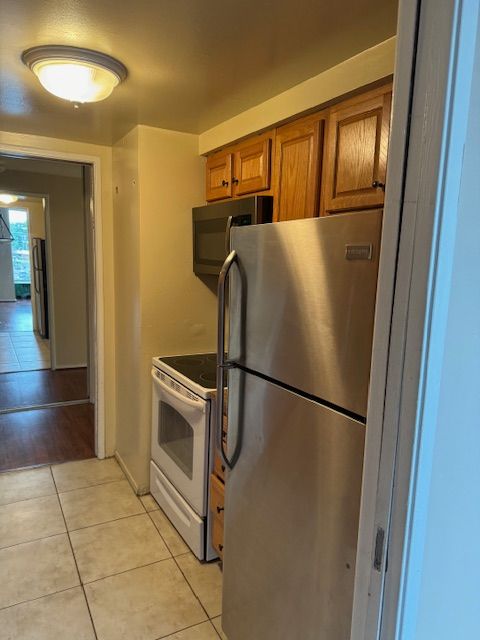 kitchen featuring light tile patterned flooring and stainless steel appliances