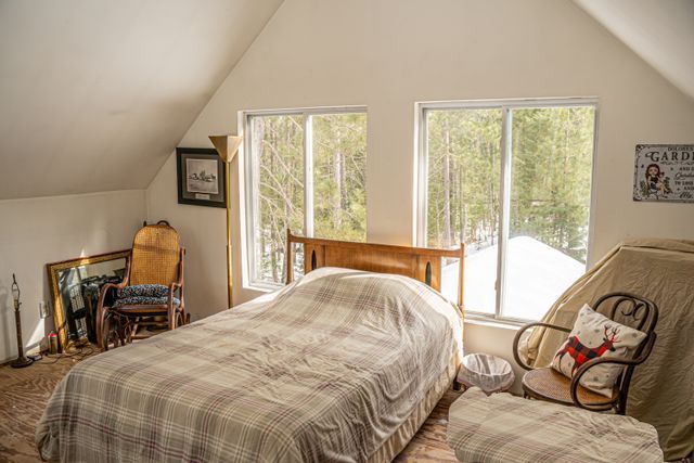 bedroom with access to outside, multiple windows, and lofted ceiling