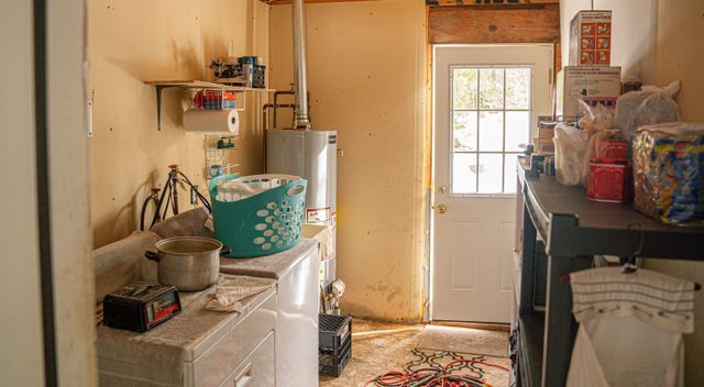 clothes washing area with separate washer and dryer and water heater