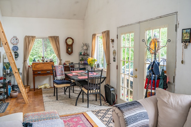 dining area with a wealth of natural light, french doors, light hardwood / wood-style floors, and vaulted ceiling