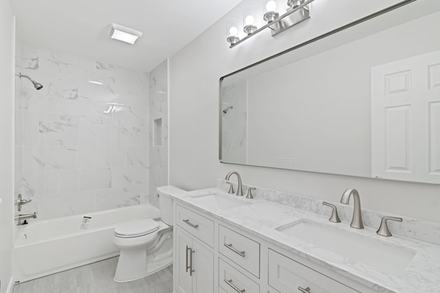 full bathroom featuring tiled shower / bath combo, toilet, and vanity