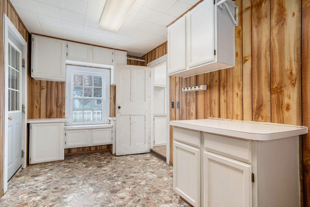 kitchen with white cabinets and wooden walls