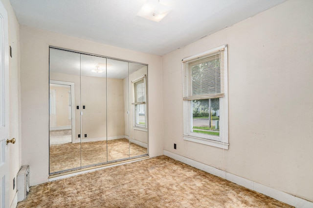 unfurnished bedroom featuring a closet and light colored carpet