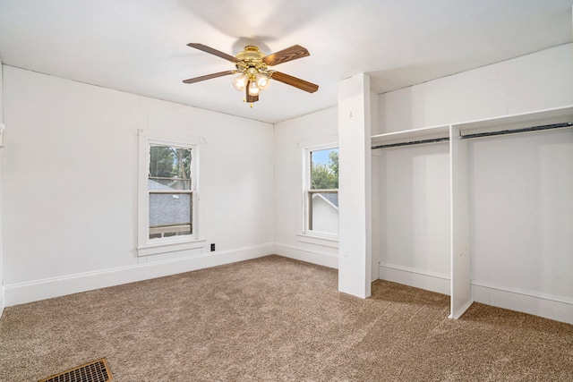 unfurnished bedroom featuring carpet flooring, multiple windows, ceiling fan, and a closet