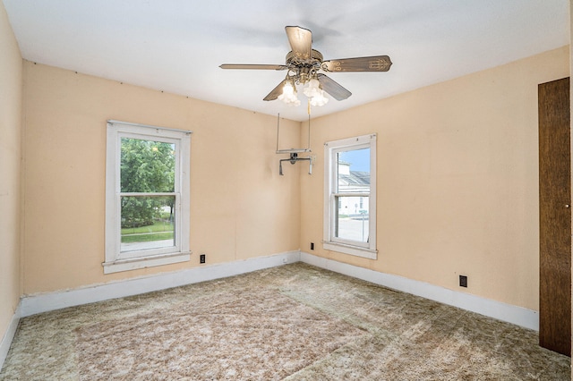 empty room featuring ceiling fan and light carpet