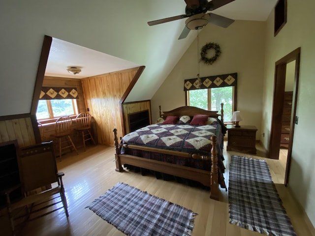 bedroom with ceiling fan, high vaulted ceiling, and light hardwood / wood-style flooring