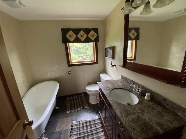 bathroom with a bathtub, vanity, and toilet