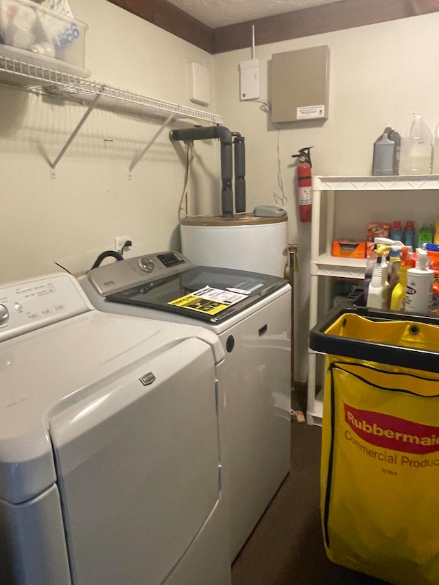 clothes washing area with washer and dryer and gas water heater