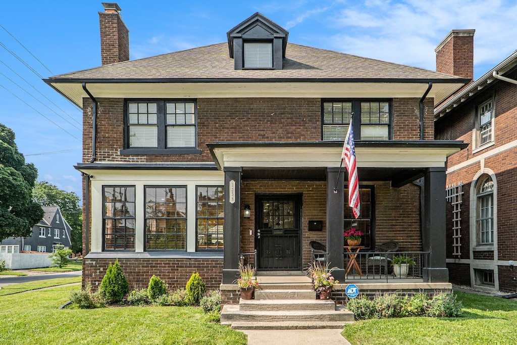 view of front of property with covered porch and a front lawn