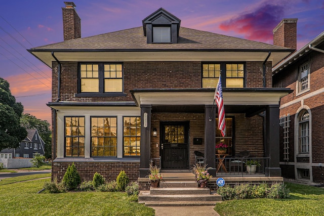 view of front facade with a porch and a yard