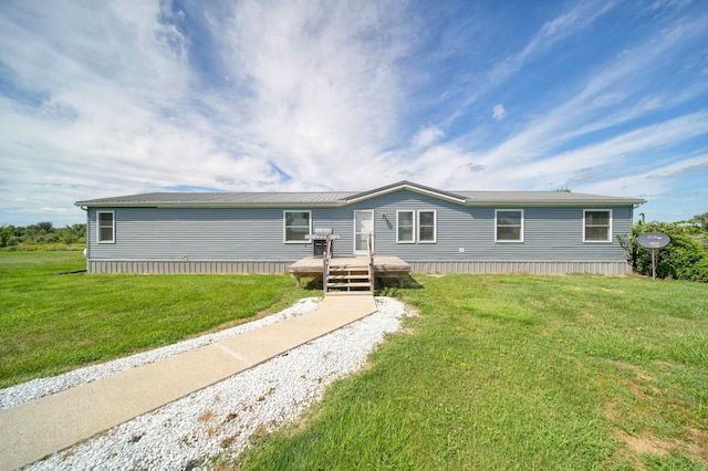 manufactured / mobile home with a wooden deck and a front lawn