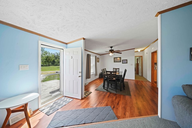 dining space with crown molding, ceiling fan, a textured ceiling, and hardwood / wood-style flooring