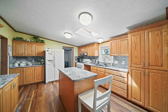 kitchen featuring a textured ceiling, a kitchen island, dark hardwood / wood-style floors, and white appliances