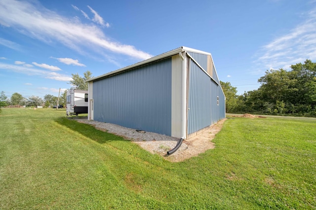 view of side of property with a yard and an outbuilding