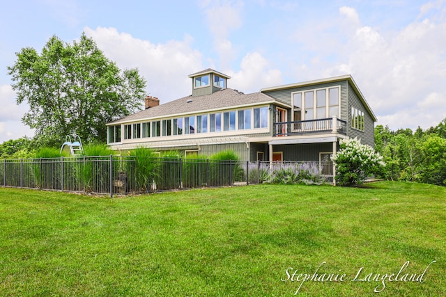 rear view of property featuring a lawn