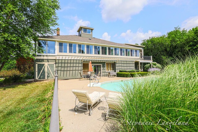 7300 Packer Dr NE, Belmont, MI 49306 - back of house featuring a patio area, a chimney, an outdoor pool, and a yard