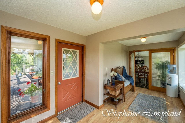 entrance foyer with a textured ceiling and light hardwood / wood-style flooring