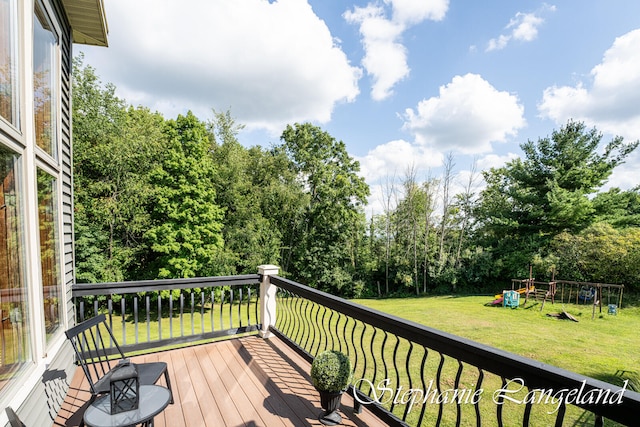 wooden terrace with a playground and a lawn