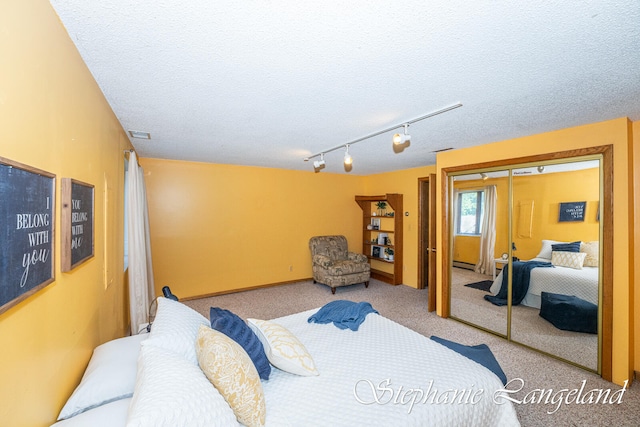 bedroom featuring a textured ceiling, light colored carpet, and a closet