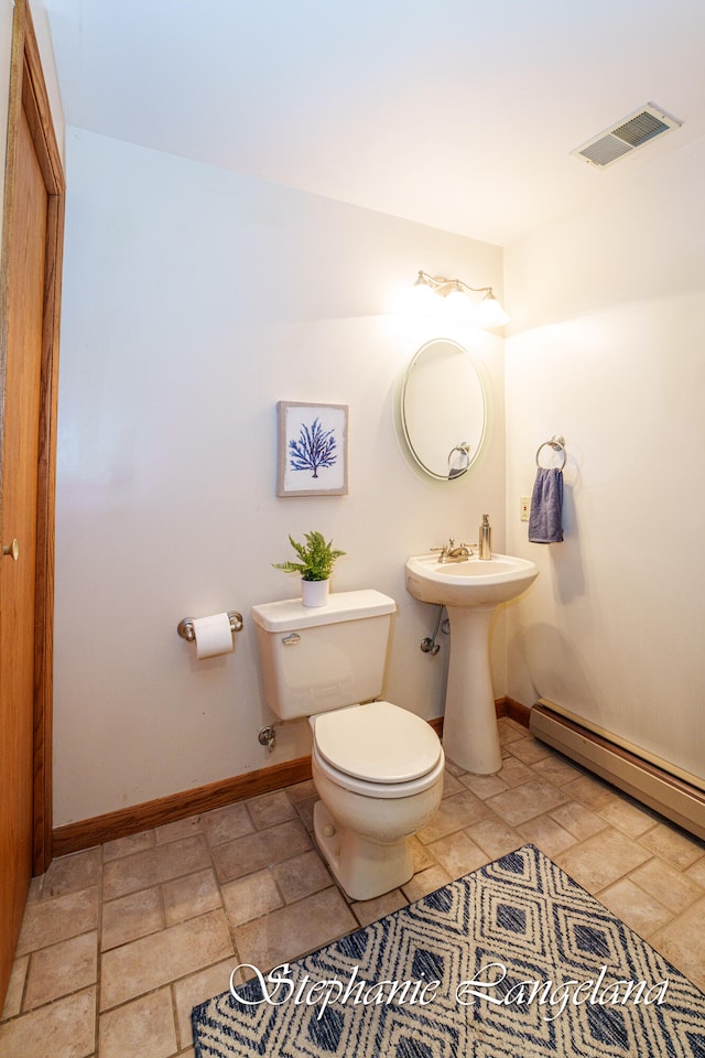 bathroom featuring toilet, sink, and a baseboard radiator