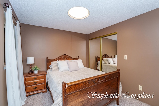 bedroom with a textured ceiling, light carpet, and a closet