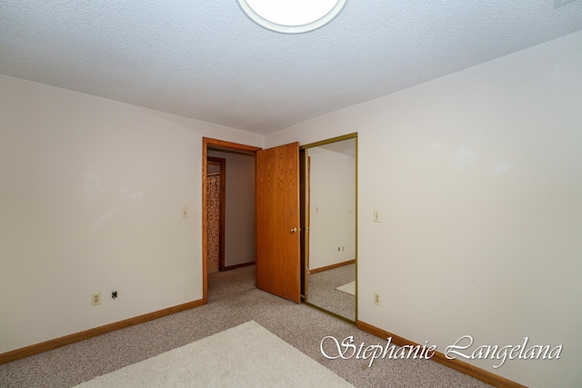 carpeted empty room featuring a textured ceiling